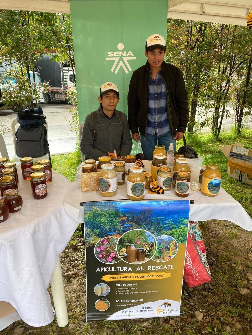 Los dos apicultores de Apicultura al Rescate en su stand de miel y polen en una feria del SENA
